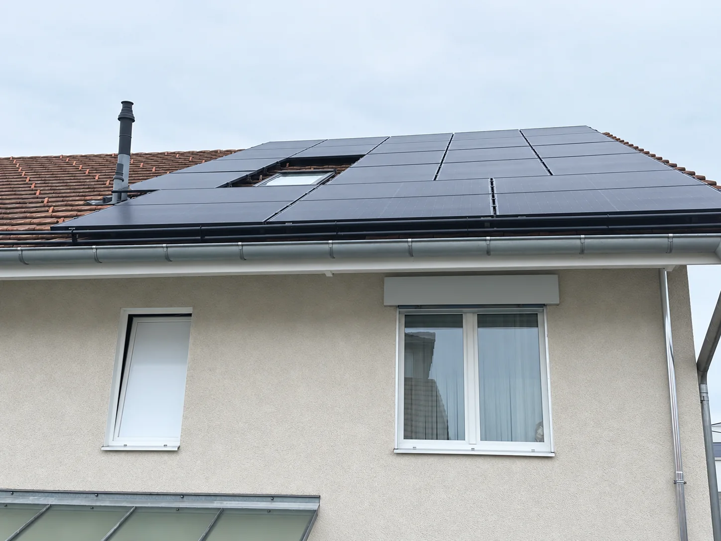 Hausfassade und Schrägdach mit montierten Solarmodulen