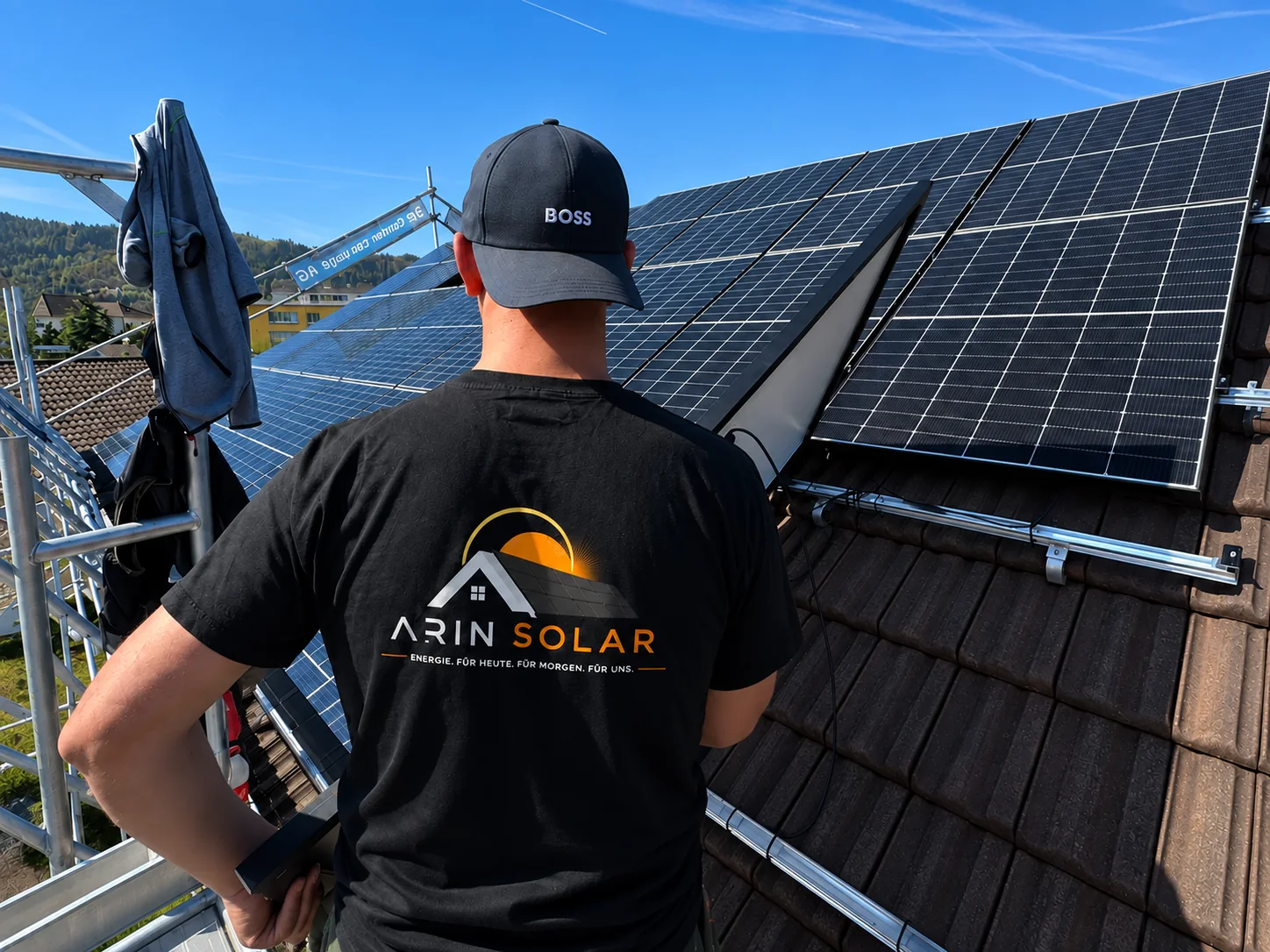 ARIN Solar Monteur neben Photovoltaikmodulen auf einem Schrägdach